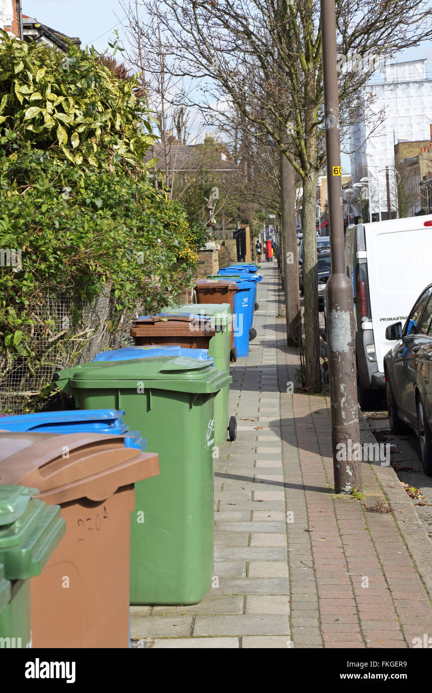 Household refuse recycling bins take up most of the pavement space on a South London street in Southwark Stock Photo