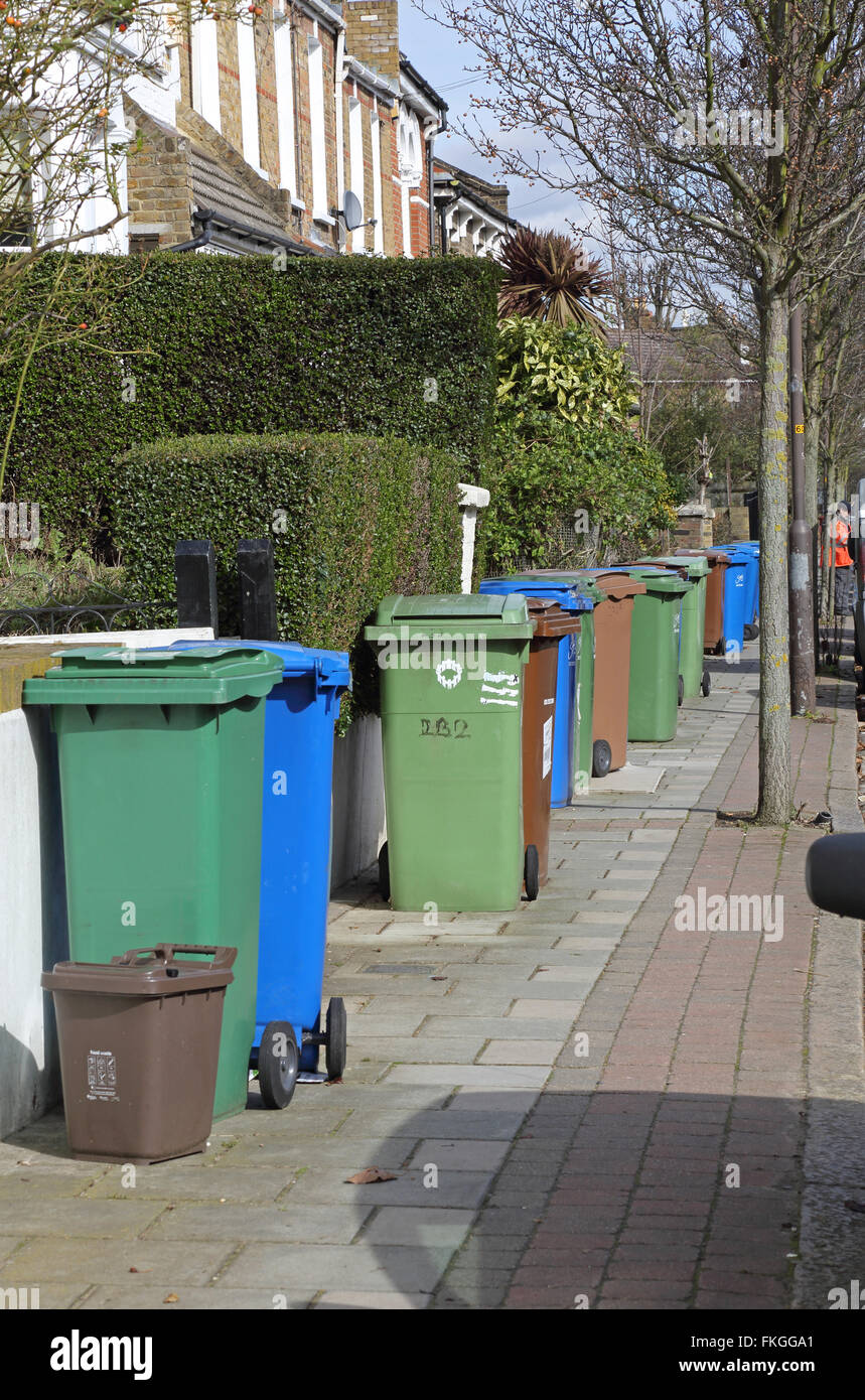 Household refuse recycling bins take up most of the pavement space on a