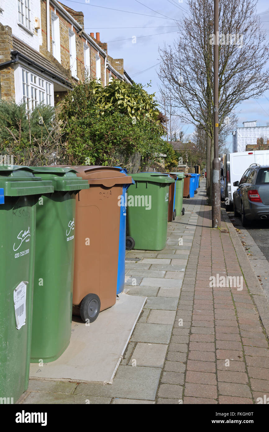 Household refuse recycling bins take up most of the pavement space on a South London street in Southwark Stock Photo