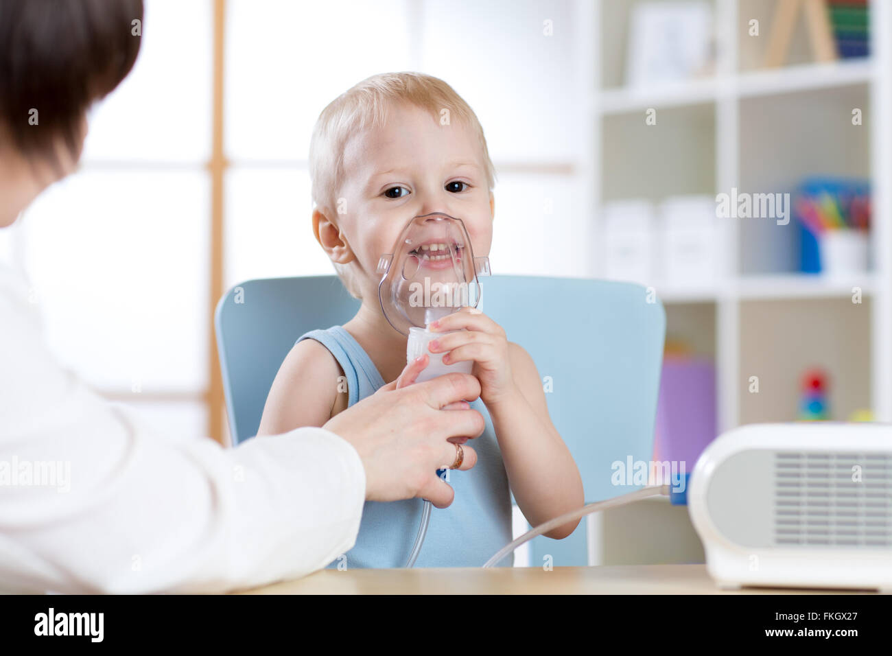 Child with asthma problems making inhalation with mask on her face
