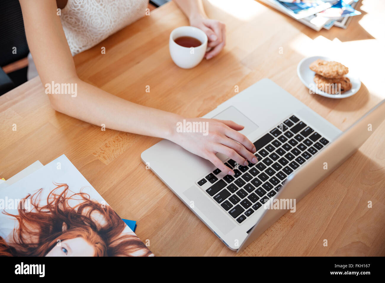 Top view of table of young woman photographer working with laptop and