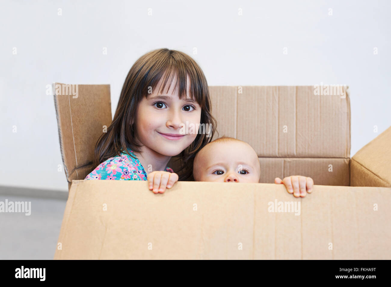 Sisters playing in a carton box Stock Photo