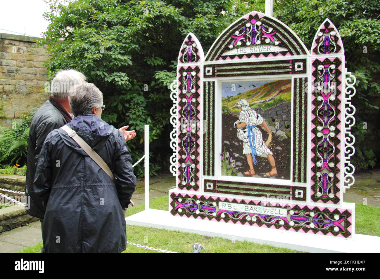 Visitors pause to look at a traditional well dressing in Bakewell town centre in the Peak District National Park England UK Stock Photo