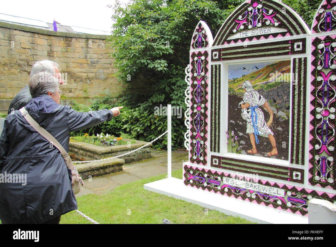 Visitors pause to look at a traditional well dressing in Bakewell town centre in the Peak District National Park England UK Stock Photo