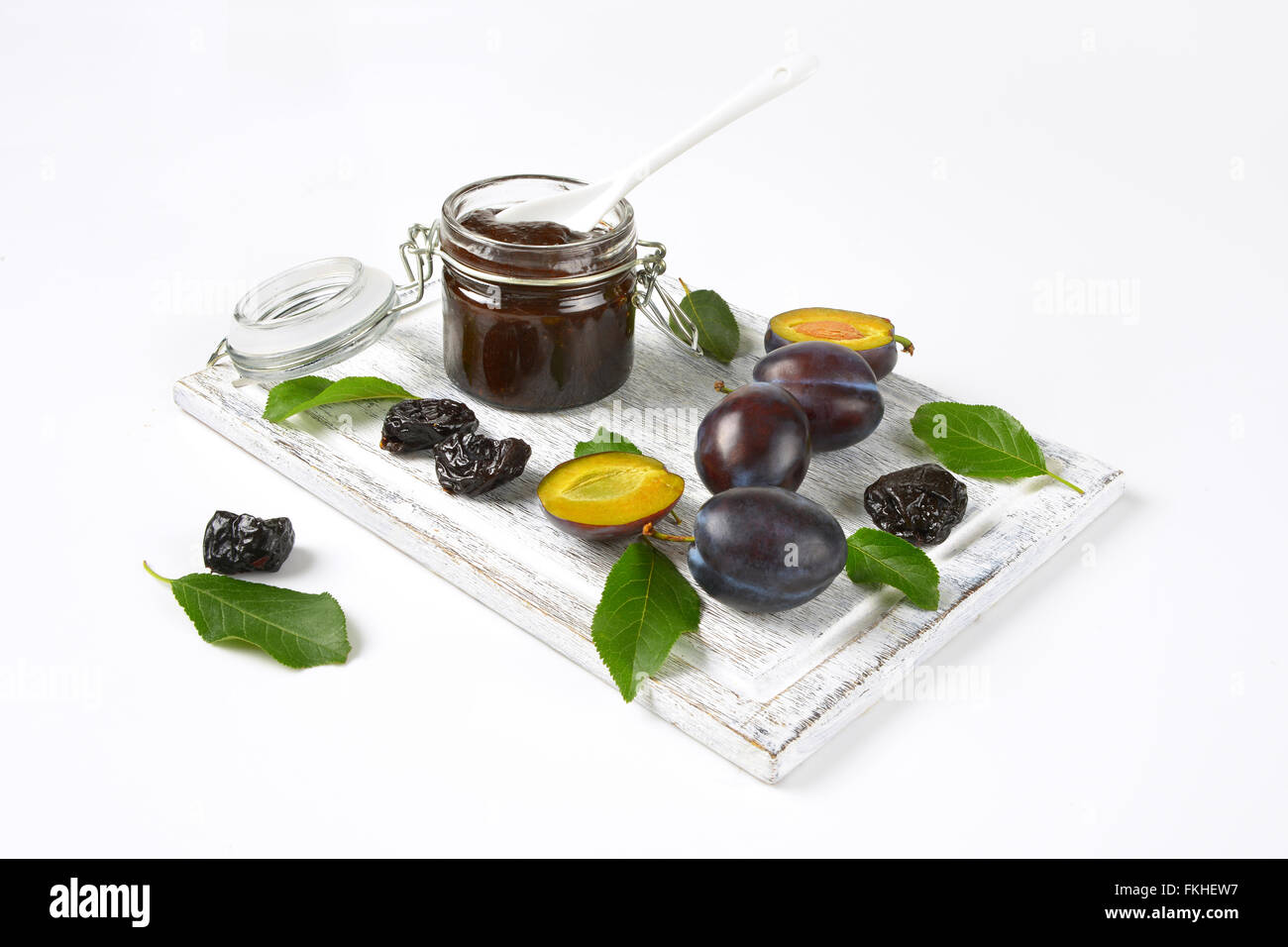 plum jam, fresh and dried plums on wooden cutting board Stock Photo