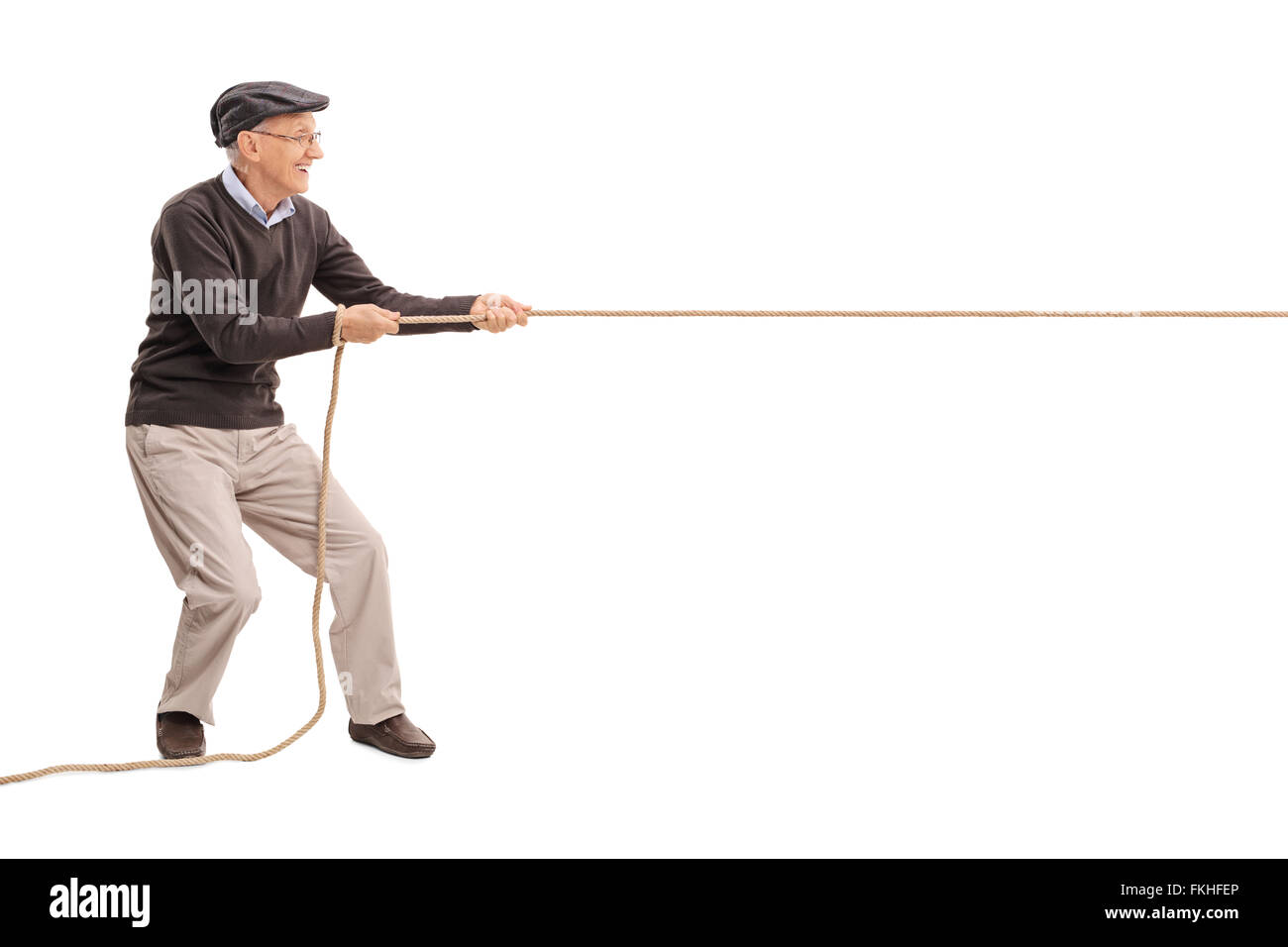 Full length profile shot of a senior gentleman pulling a rope isolated on white background Stock Photo