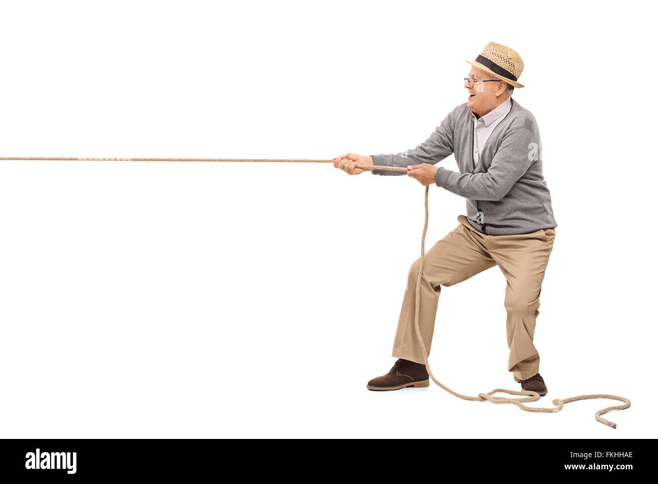 Studio shot of a cheerful senior pulling a rope isolated on white background Stock Photo