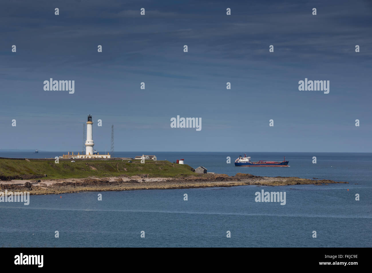 The lighthouse and beach at Aberdeen, Scotland, UK, with a vessel leaving harbour Stock Photo
