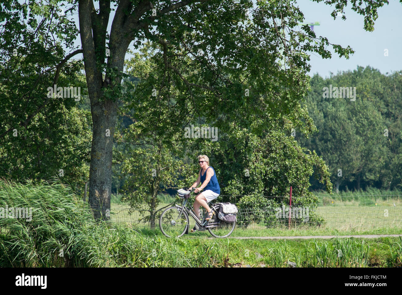 Woman cycling along the Amster river. Stock Photo