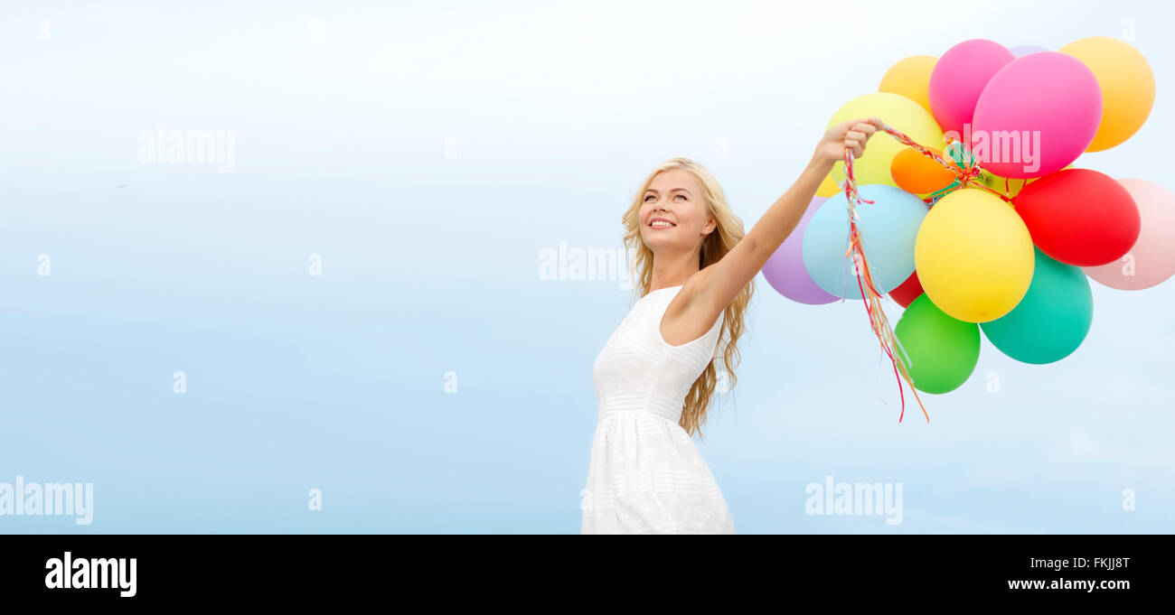 smiling woman with colorful balloons outside Stock Photo