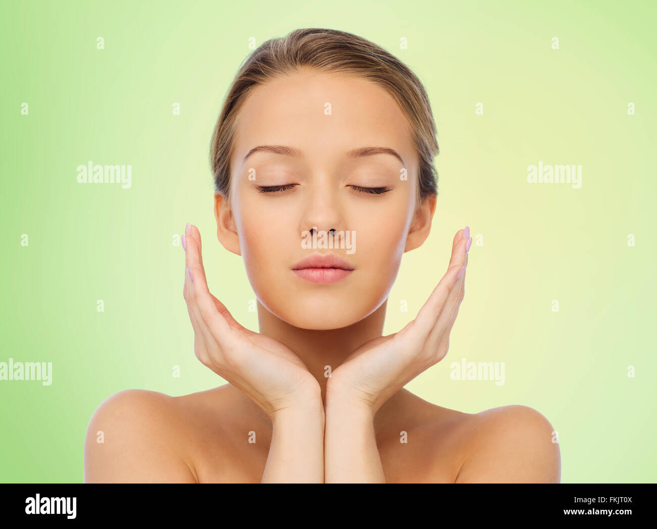 young woman face and hands over green Stock Photo