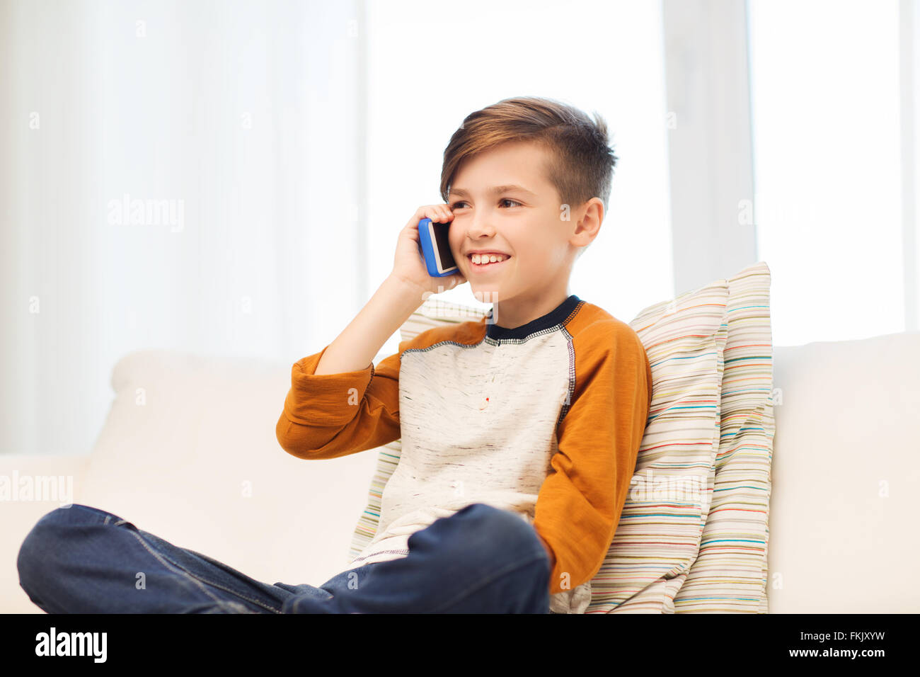 happy boy calling on smartphone at home Stock Photo