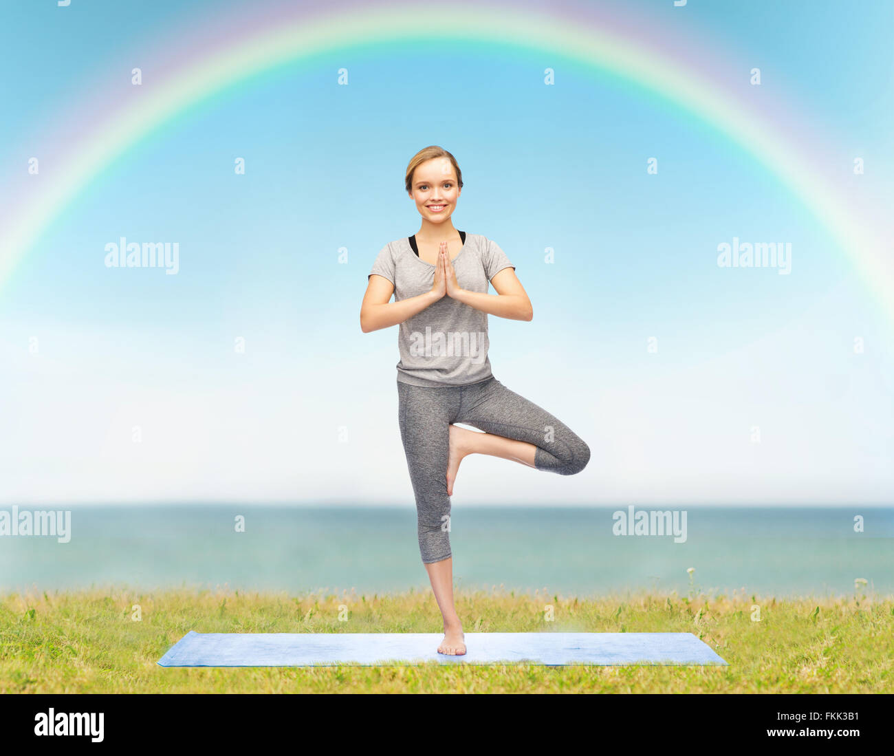 woman making yoga in tree pose on mat Stock Photo - Alamy