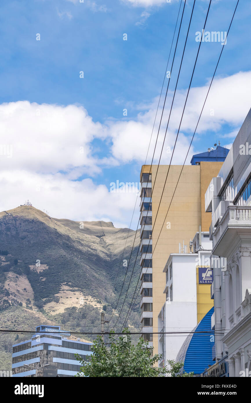 Day urban scene photo of modern buildings and big mountains at background in a district of Quito city, the capital of Ecuador in Stock Photo