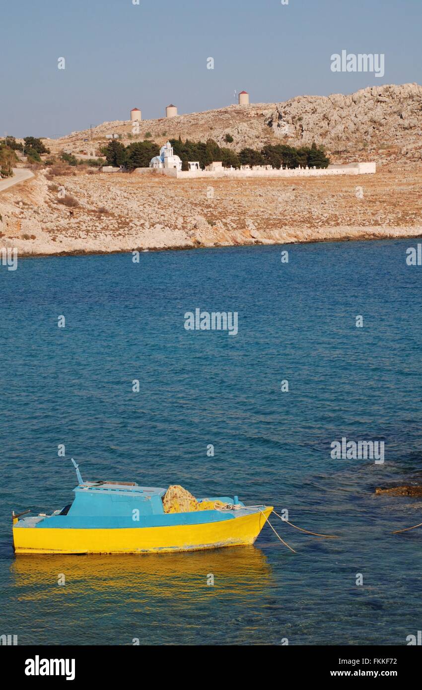 A small wooden fishing boat moored off Pondamos beach at Emborio on the Greek island of Halki. Stock Photo