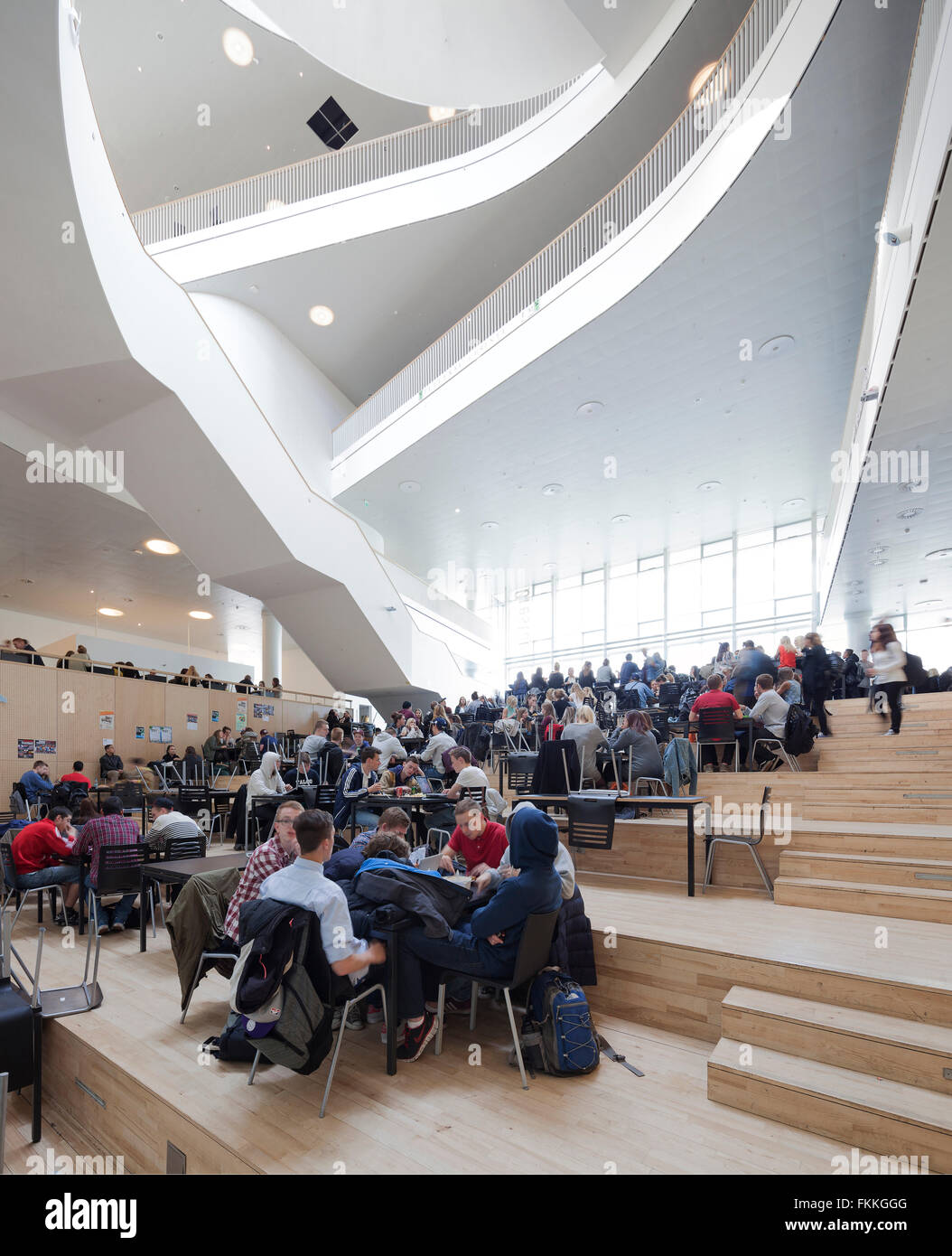 An interior view of Orestad College, many students can be seen seated. Stock Photo