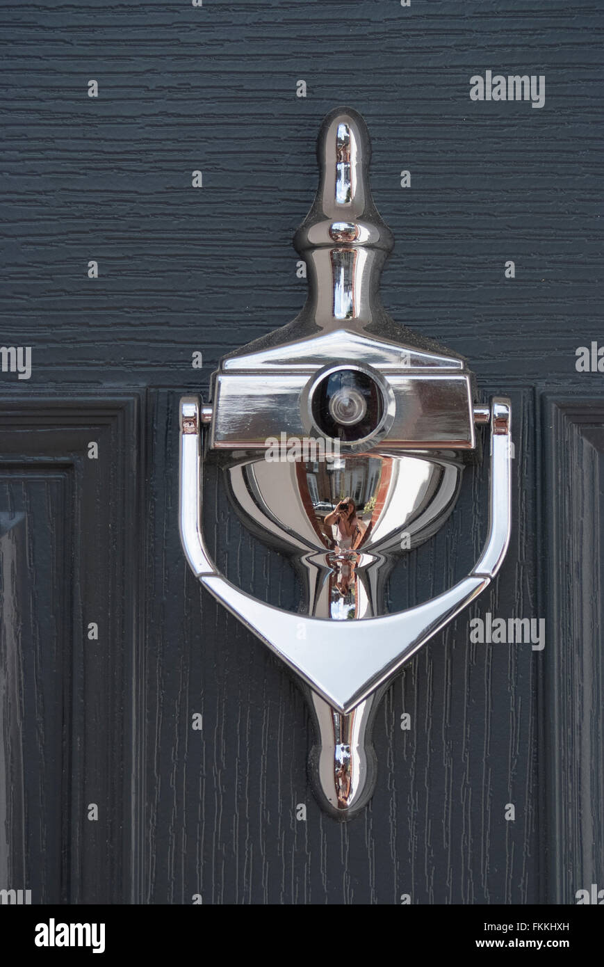 A silver door knocker on a black panel door, of a residential house. Stock Photo