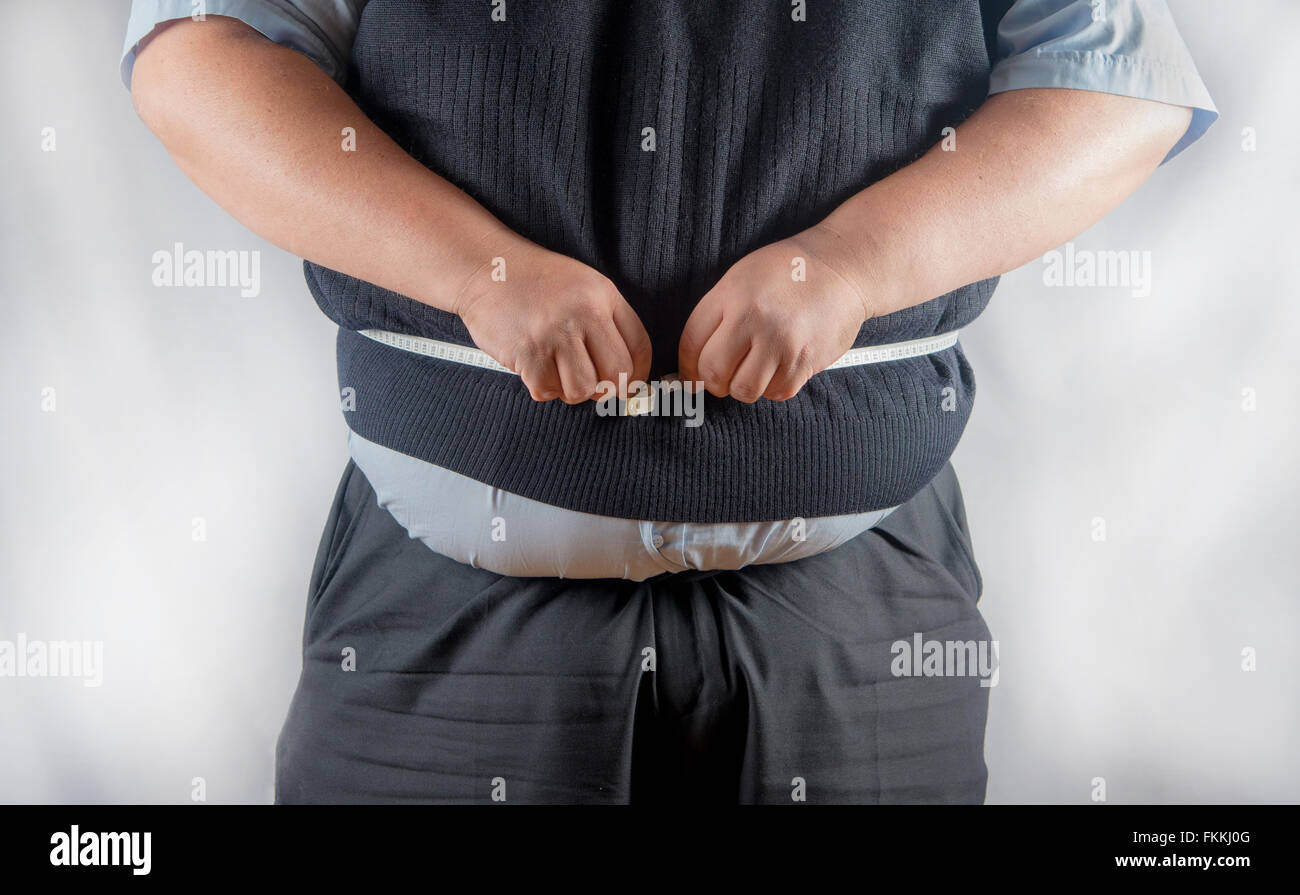 Very over weight man measuring his waist Stock Photo