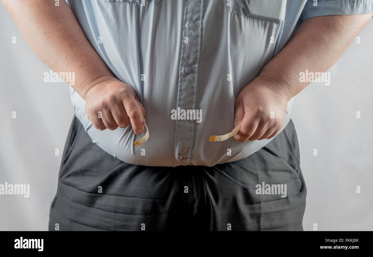 Very over weight man measuring his waist Stock Photo