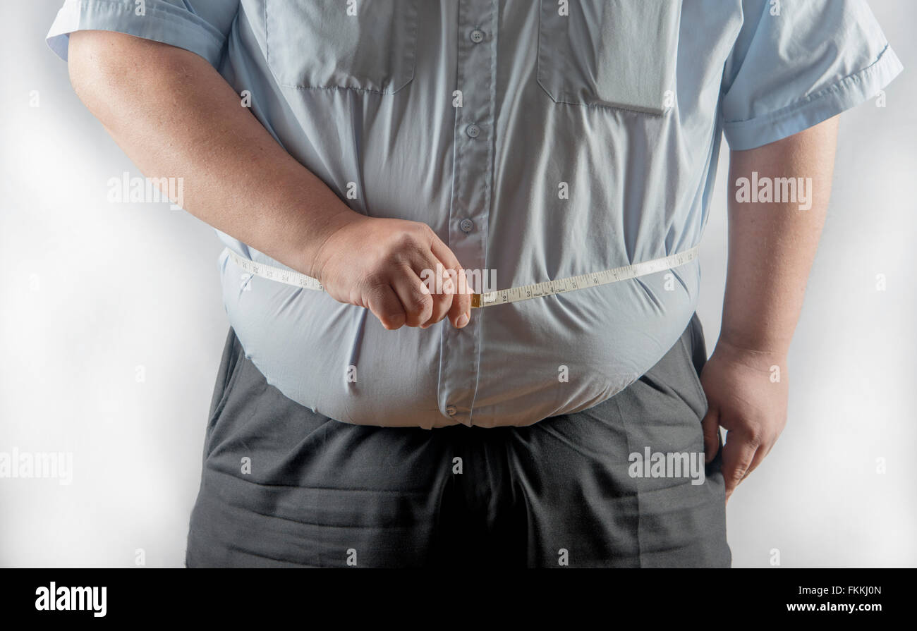 Very over weight man measuring his waist Stock Photo