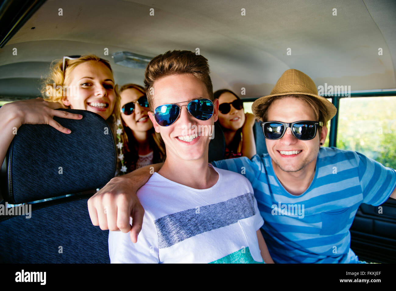 Teenage boys and girls inside an old campervan, roadtrip Stock Photo