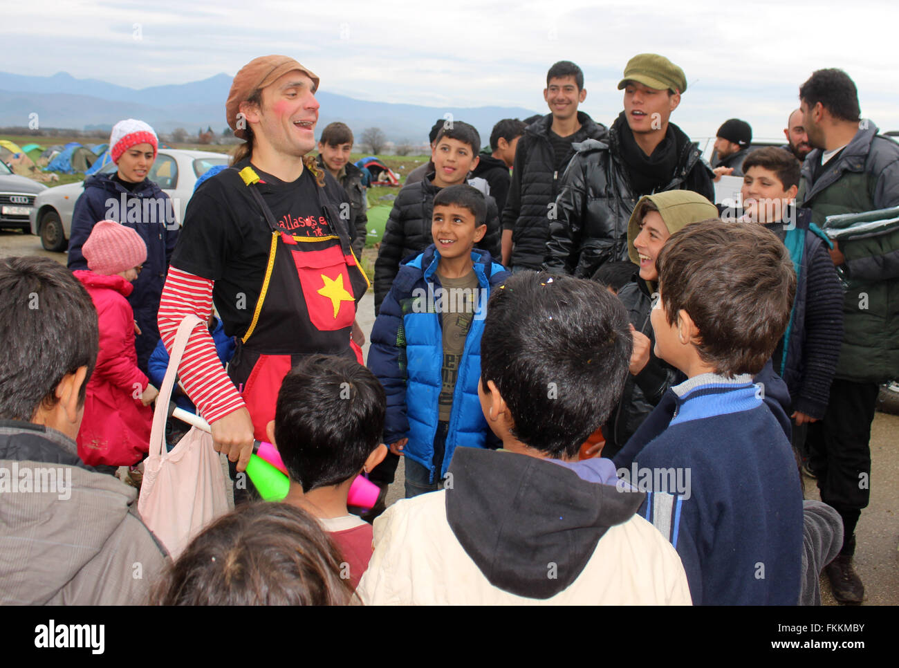 Idomeni, Greece. 9th Mar, 2016. A member of the group 'Rebel Clowns' speaking with children in the refugee camp at the Greek-Macedonian border in Idomeni, Greece, 9 March 2016. Photo: Gregor Mayer/dpa/Alamy Live News Stock Photo