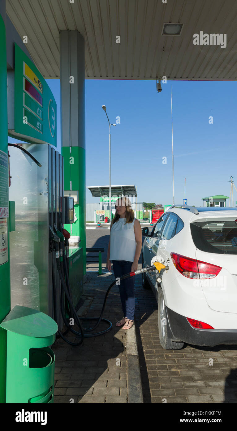 Miory, Belarus - July 25, 2015: the girl at gas station fills in gasoline in the car. Stock Photo