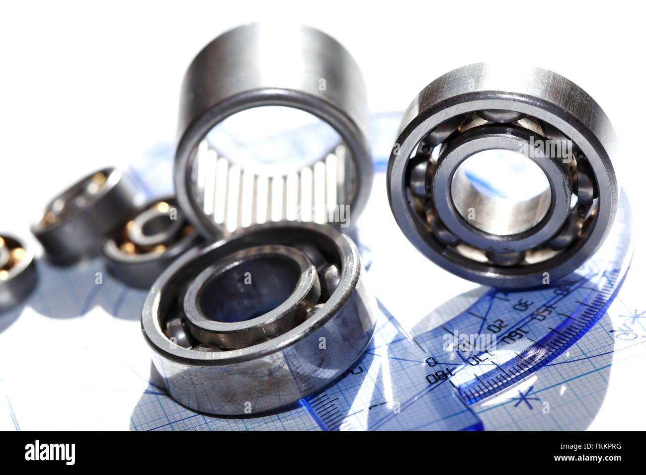 Industrial concept. Few ball bearings near ruler on graph paper