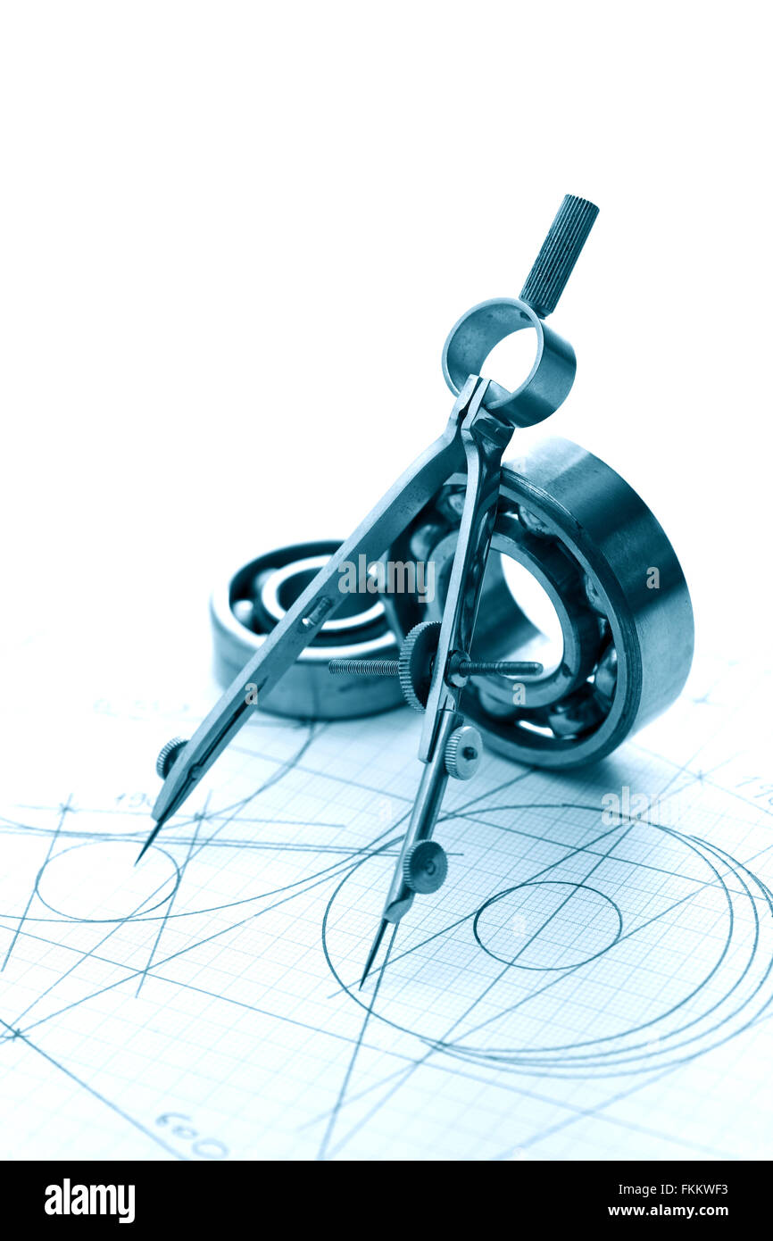 Industrial concept. Divider near ball bearings on graph paper