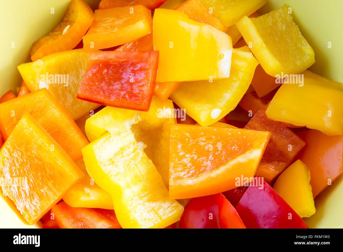 Small bell pepper pieces in a bowl in different colours, yellow, red and orange Stock Photo