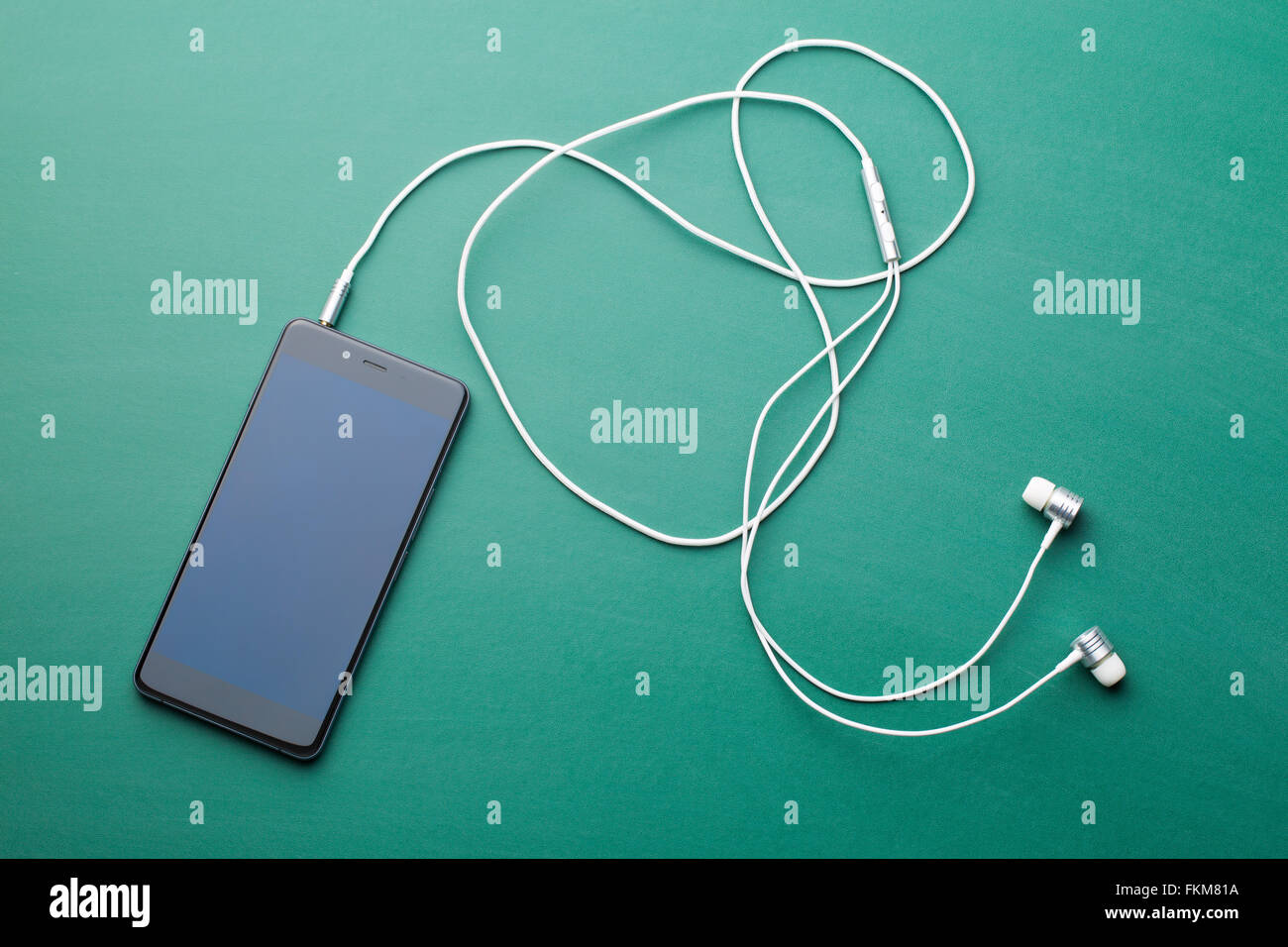 earphones and cellphone on green chalkboard Stock Photo