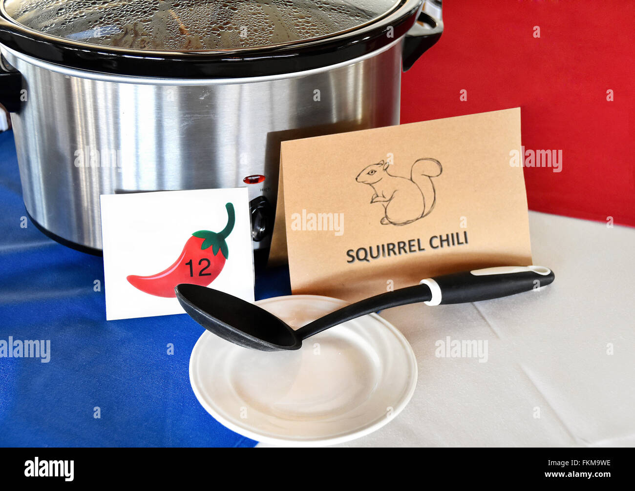 Crock pot with squirrel chili sign and black ladle on plate for chili cook off contest. Stock Photo