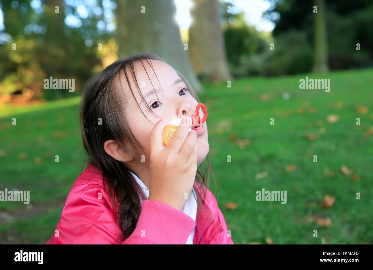 Portrait of little girl playing with bubble blower Stock Photo - Alamy