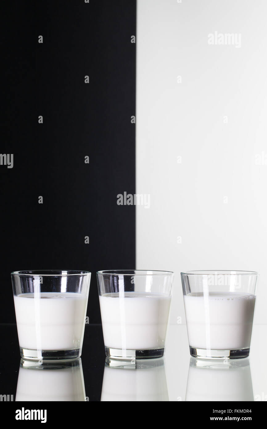 Glasses of milk   isolated on black and white background and glass desk Stock Photo