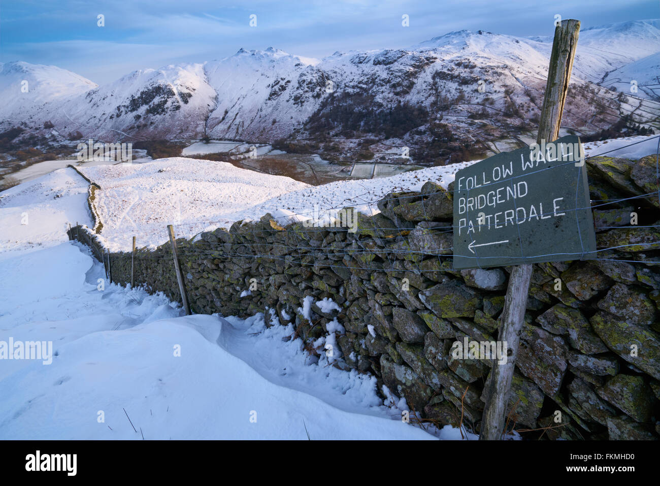 Signpost by a stone wall pointing towards Bridgend, Patterdale in the English Lake District. Stock Photo