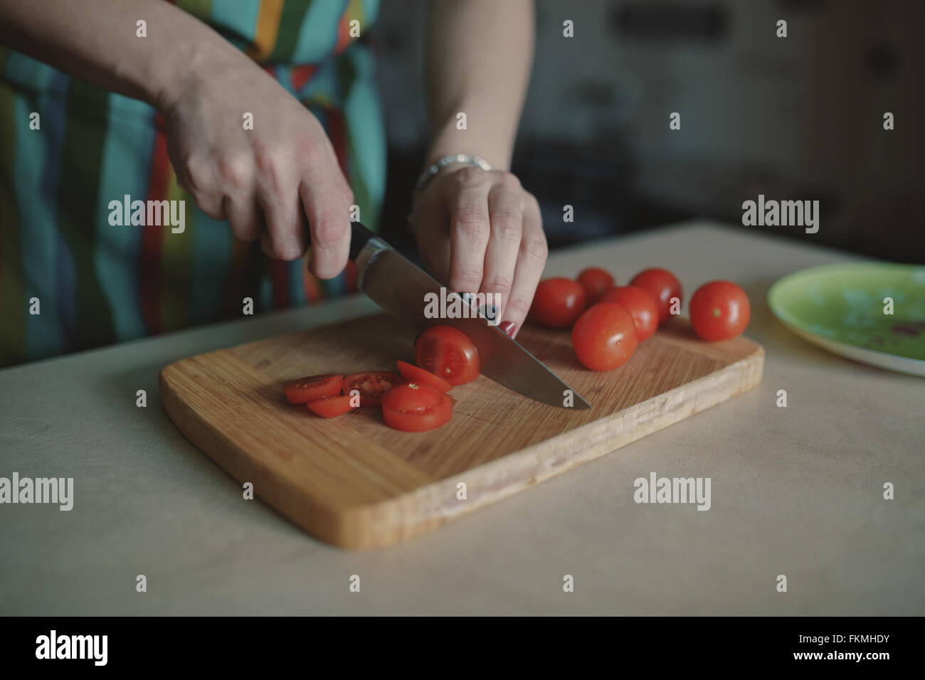 Young woman slicing tomatoes Stock Photo - Alamy