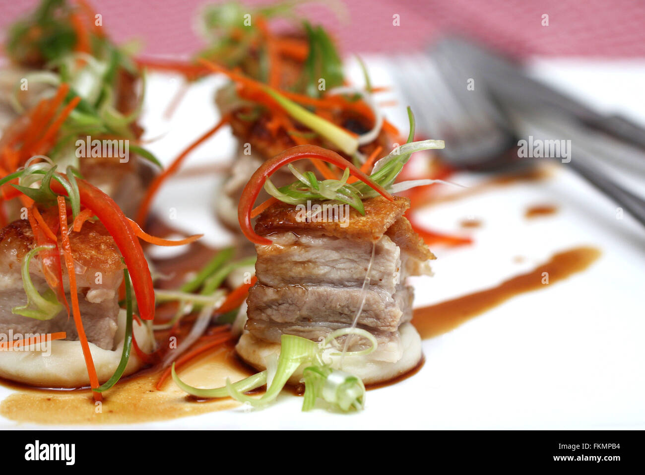 Delicious roasted pork belly cubes on mashed potato with caramel sauce