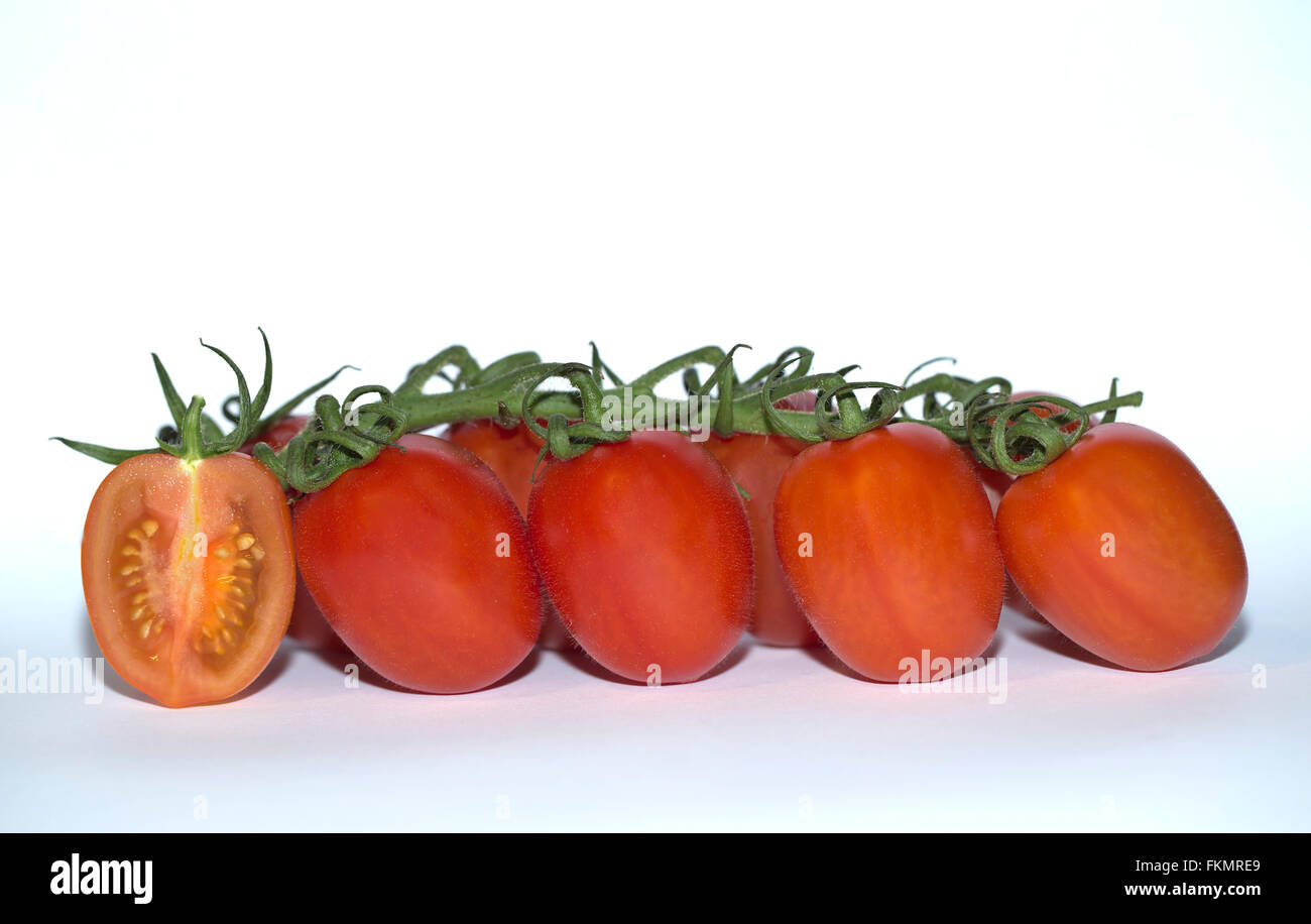 Vine tomatoes with one cut in half Stock Photo
