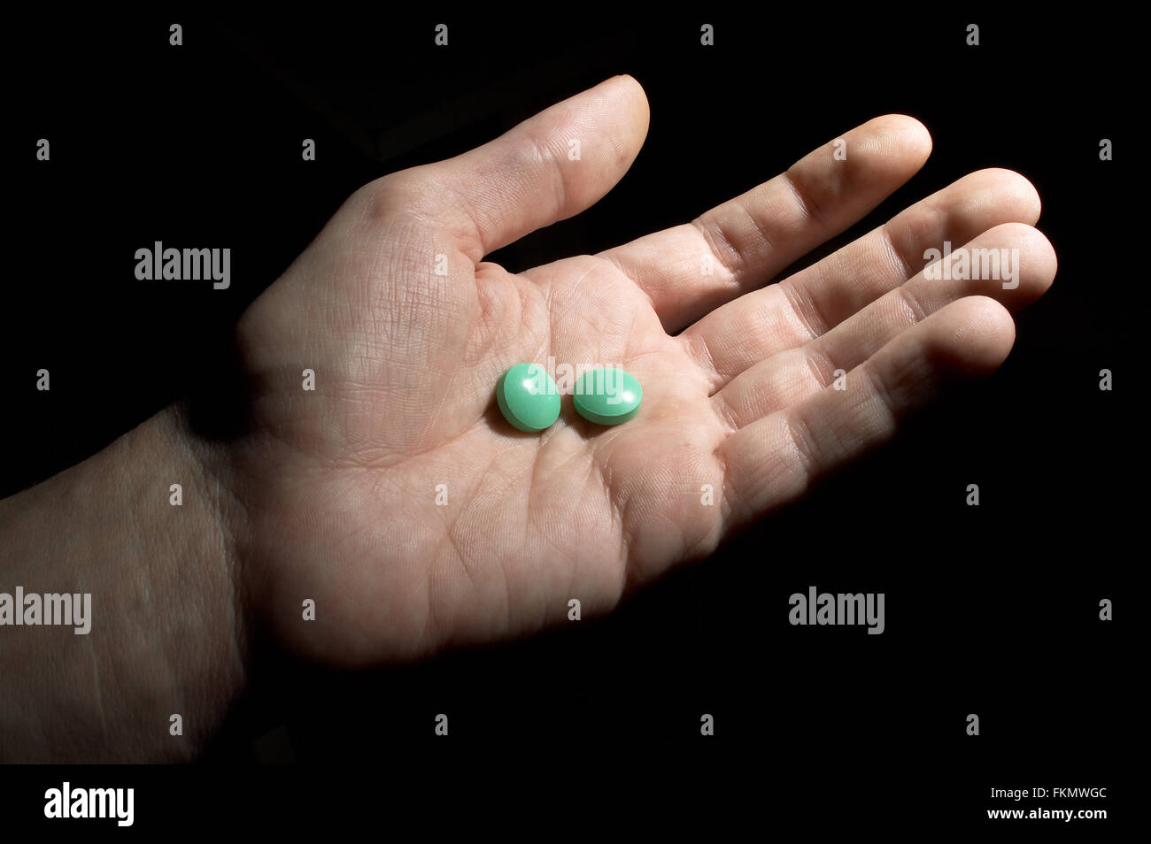 Two green tablets on the opened palm Stock Photo
