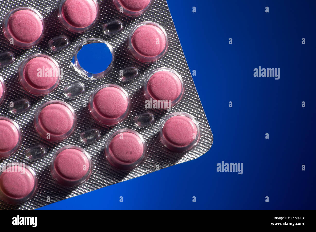 Pink tablets on a dark blue background Stock Photo