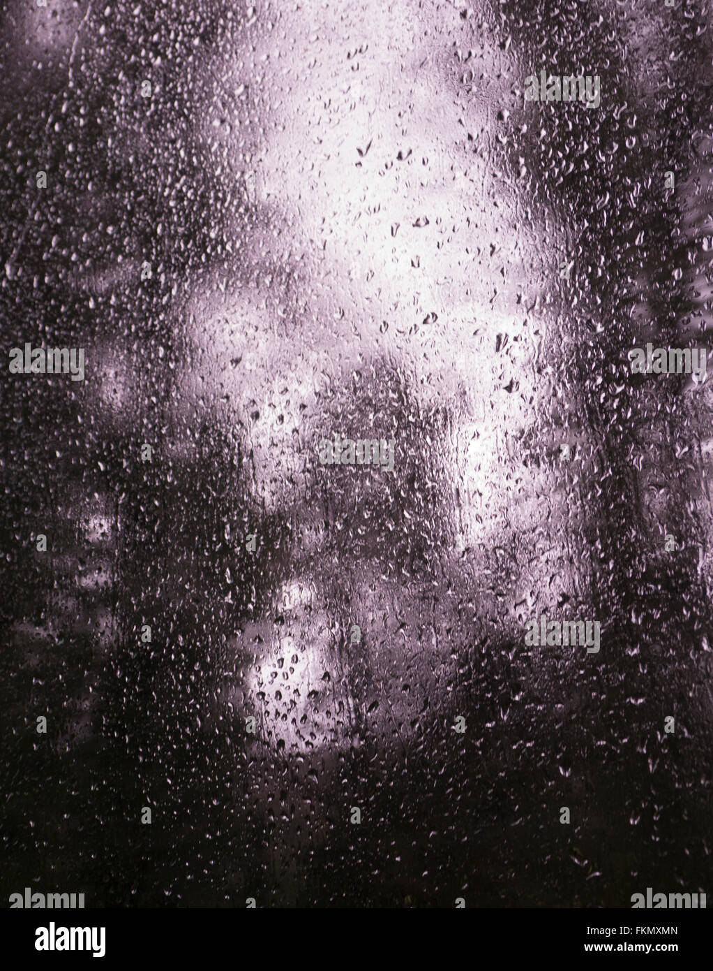 Rain drops forming on window  moveing train , background of out of focus trees. Stock Photo
