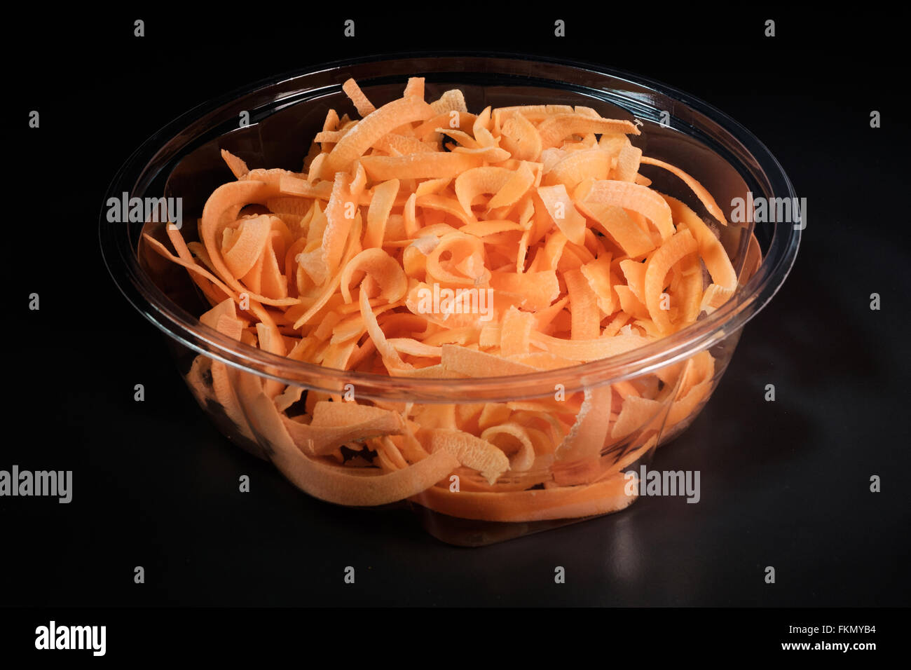 Carrots cut into julienne strips in a bowl with black background Stock Photo