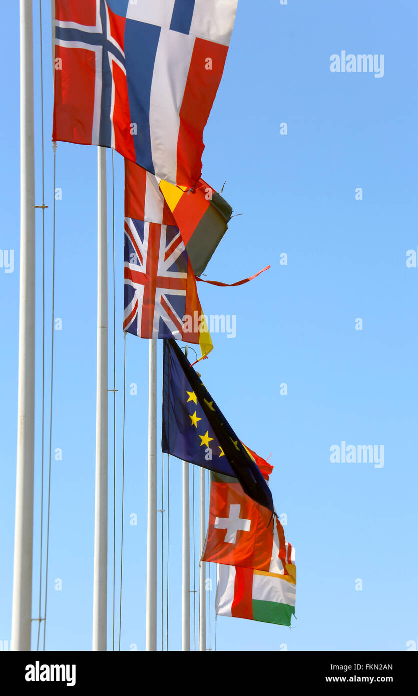 many flags of many nations in the wind on a sunny day with blue sky Stock Photo