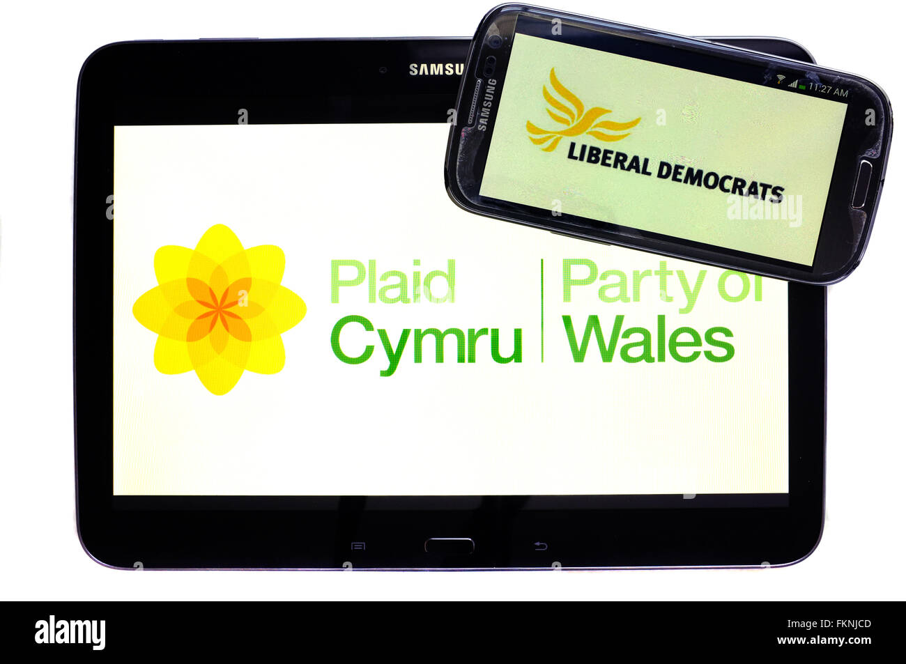 The Plaid Cymru and Lib Dem logos displayed on the screens of a tablet and a smartphone against a white background. Stock Photo