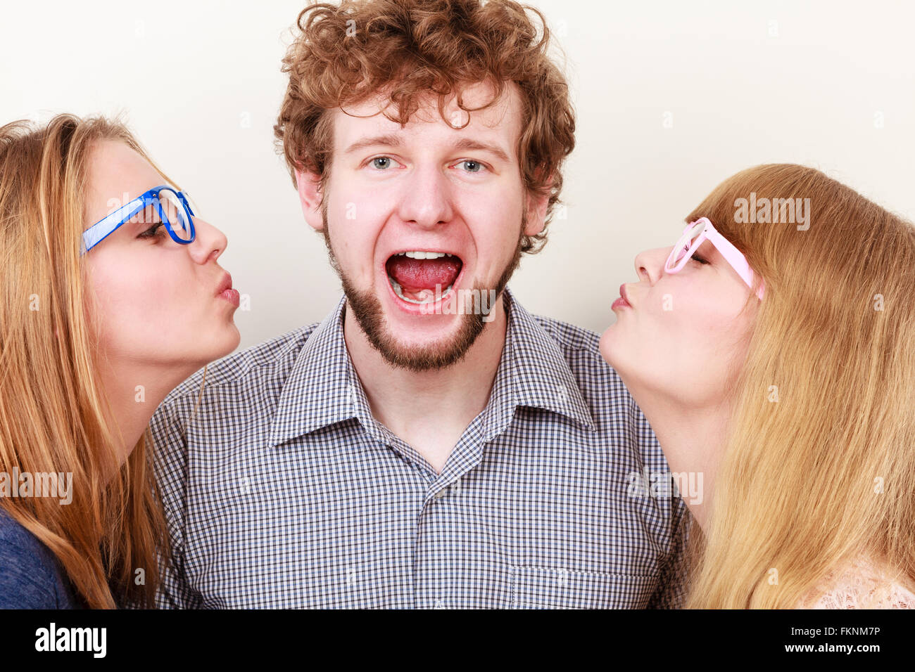 Two Pretty Young Women In Glasses Kissing Handsome Man Love Triangle