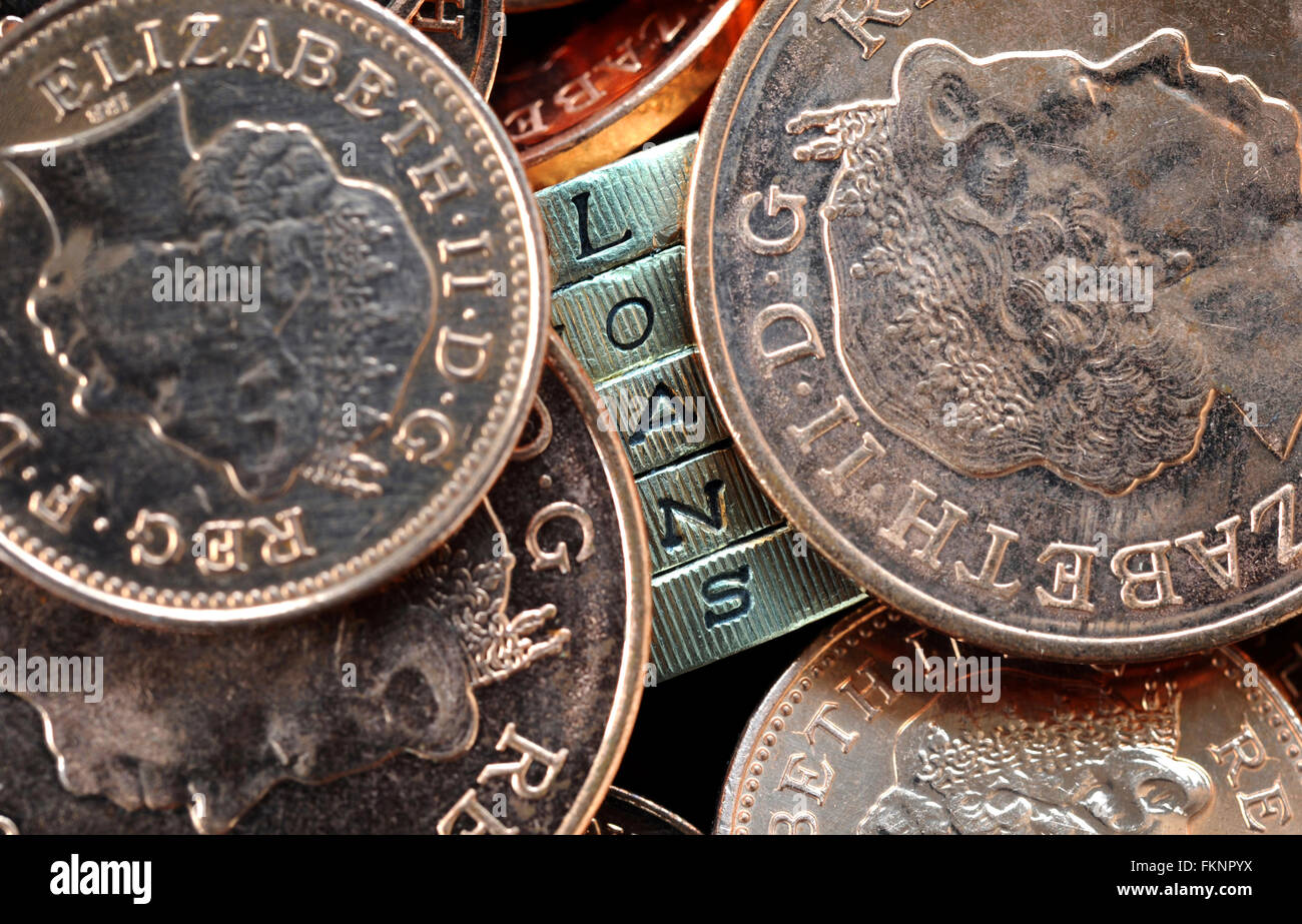 ONE POUND COIN EDGE LETTERS SPELLING 'LOANS' WITH OTHER COINS RE PAY DAY LOANS LENDING INCOMES WAGES BENEFITS REPAYMENTS CASH UK Stock Photo