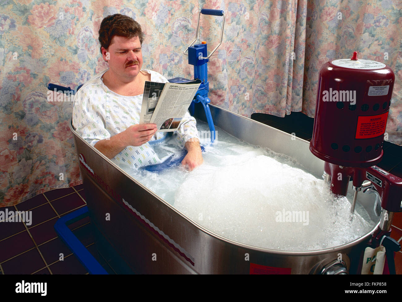 Male patient in whirlpool tub for physical therapy Stock Photo