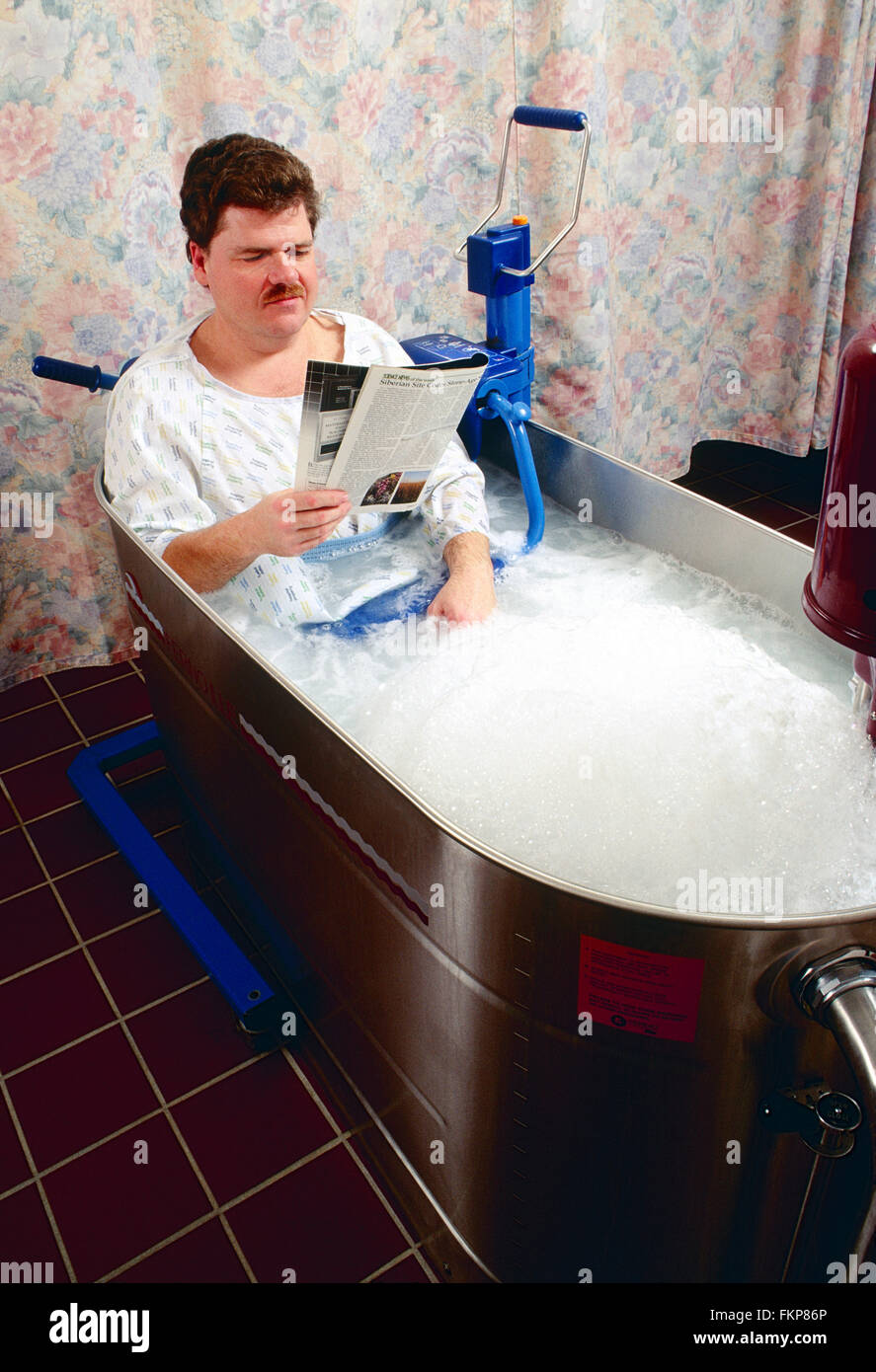 Male patient in whirlpool tub for physical therapy Stock Photo