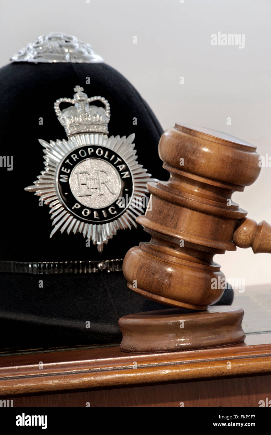 POLICE GAVEL COURT OATH EVIDENCE JUDGEMENT  Legal concept Metropolitan Police helmet with judges gavel in London law courts situation UK Stock Photo