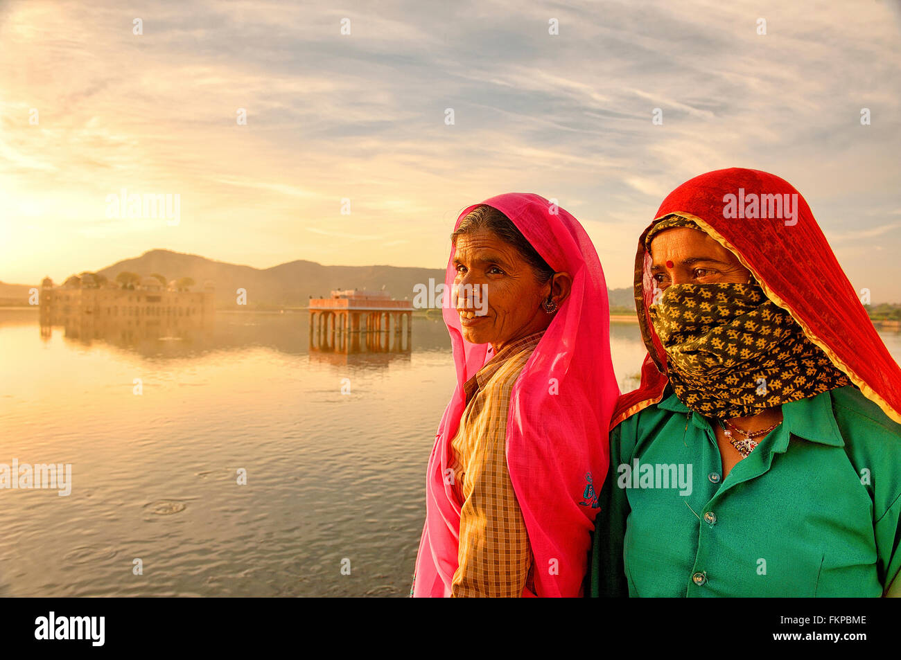 Local people visiting the Jal Mahal historical site during sunrise. Stock Photo